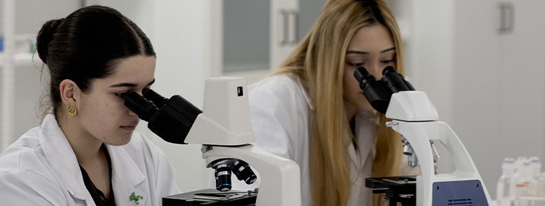 Alumnas de iLERNA observando a través del microscopio.