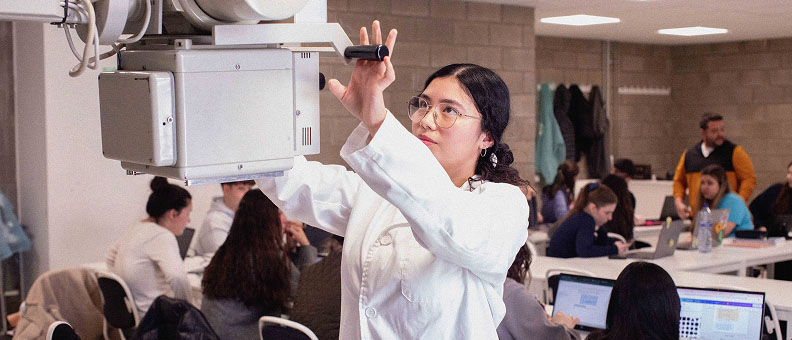 Alumna de iLERNA manipulando máquina del sector sanitario.